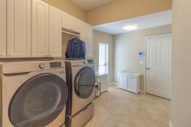 laundry area with separate washer and dryer and cabinets