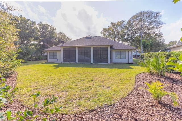 rear view of property featuring a sunroom and a yard