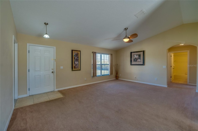 foyer entrance with light colored carpet, vaulted ceiling, and ceiling fan