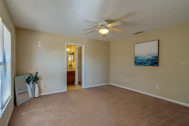 empty room with ceiling fan and light carpet