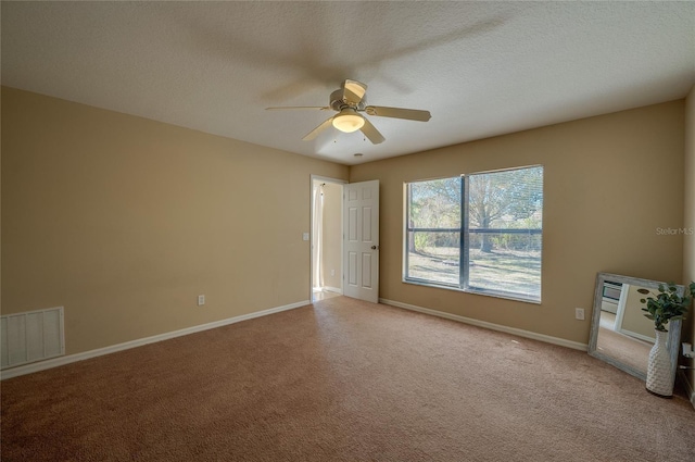 carpeted spare room with ceiling fan and a textured ceiling