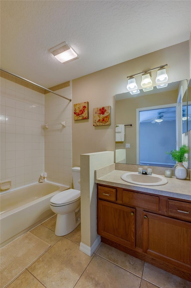 full bathroom with vanity, tile patterned flooring, tiled shower / bath combo, toilet, and a textured ceiling