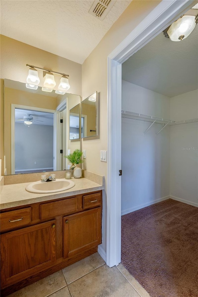 bathroom featuring tile patterned floors, vanity, and a textured ceiling