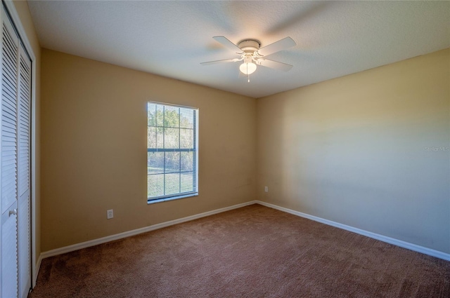 spare room featuring ceiling fan and carpet floors