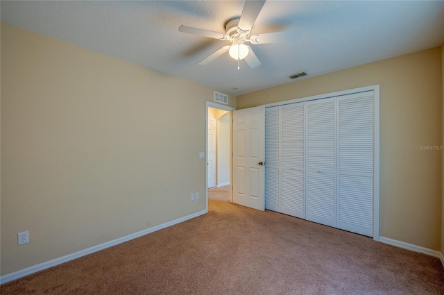 unfurnished bedroom with ceiling fan, a closet, and light colored carpet