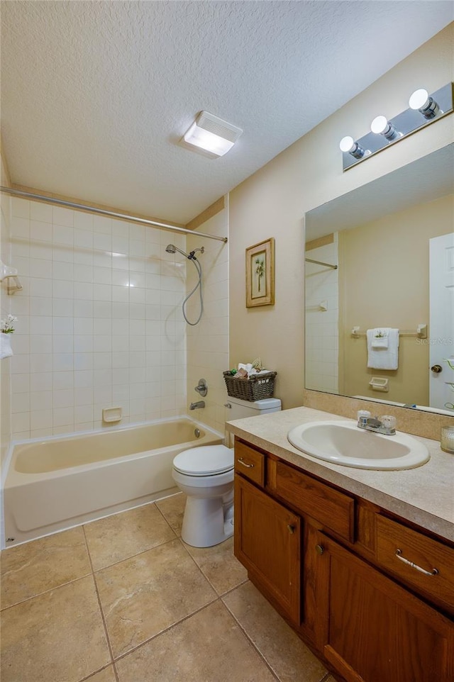 full bathroom featuring tiled shower / bath, vanity, a textured ceiling, and toilet