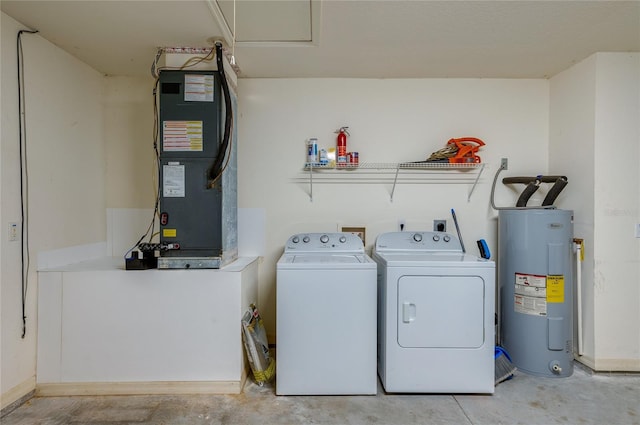 clothes washing area featuring washer and dryer, electric water heater, and heating unit