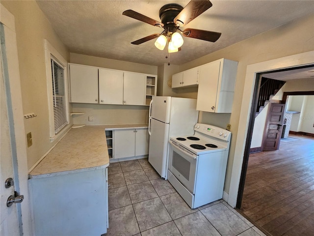 kitchen with electric range, ceiling fan, white cabinetry, and light tile patterned floors