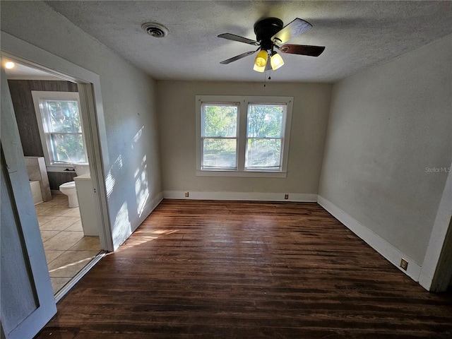 spare room featuring wood-type flooring, a textured ceiling, and ceiling fan