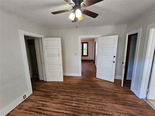 unfurnished bedroom with a textured ceiling, ceiling fan, and dark wood-type flooring