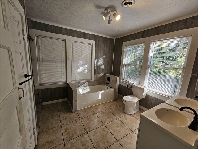 bathroom with vanity, wood walls, toilet, a textured ceiling, and a tub