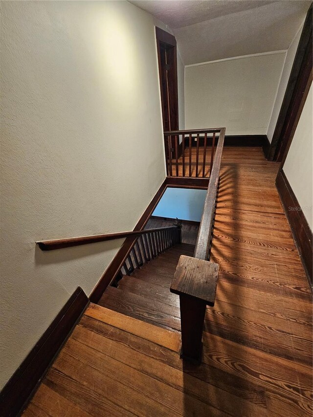 staircase featuring hardwood / wood-style floors and vaulted ceiling