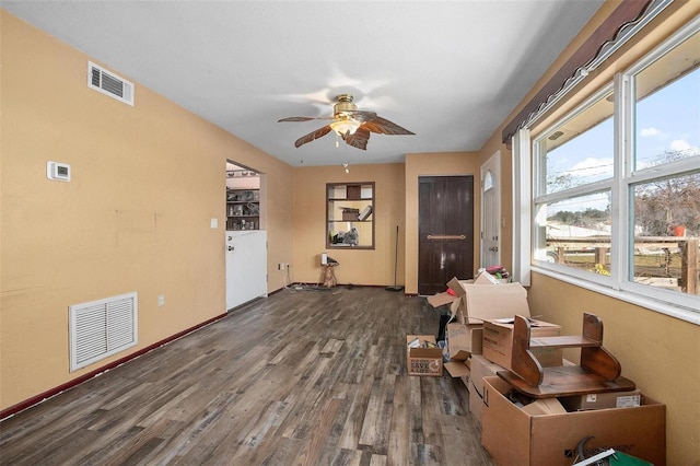 interior space with ceiling fan, a healthy amount of sunlight, and dark hardwood / wood-style floors