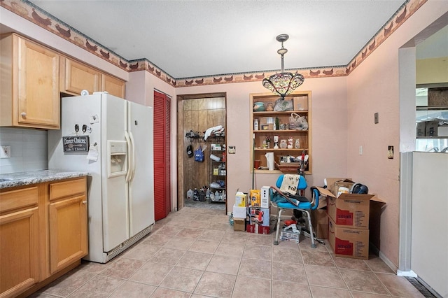 kitchen with light brown cabinetry, backsplash, decorative light fixtures, and white fridge with ice dispenser