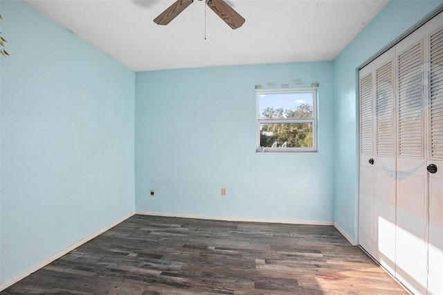 unfurnished bedroom with ceiling fan, a closet, and dark wood-type flooring