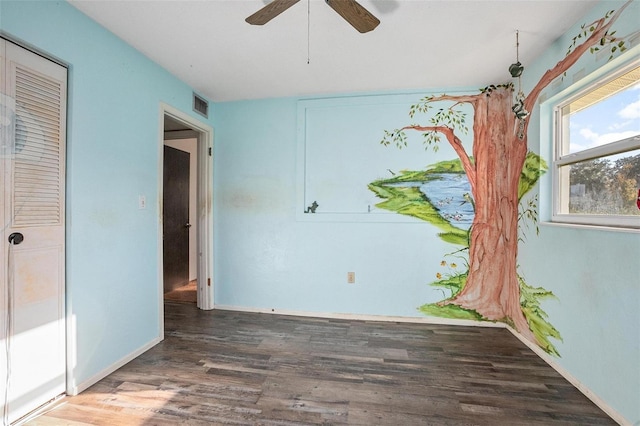 unfurnished bedroom with ceiling fan, dark hardwood / wood-style flooring, and a closet