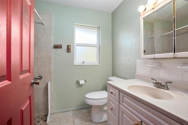 bathroom with decorative backsplash, tile patterned floors, a tile shower, vanity, and toilet