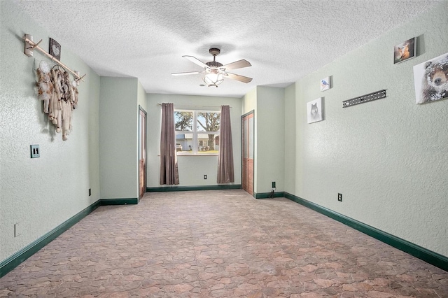 carpeted spare room featuring ceiling fan and a textured ceiling