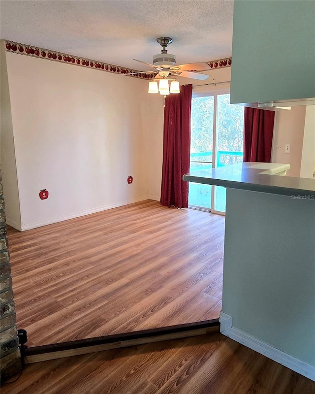 interior space featuring hardwood / wood-style floors, ceiling fan, and a textured ceiling