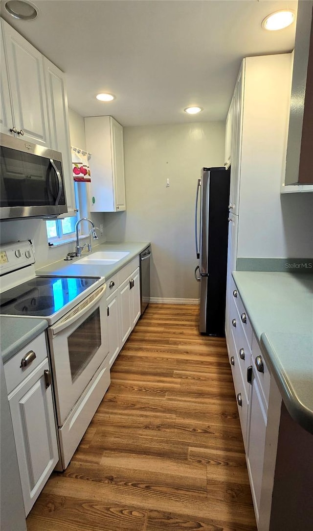 kitchen featuring dark hardwood / wood-style floors, white cabinetry, sink, and appliances with stainless steel finishes