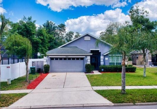 view of front of home with central AC unit, a garage, and a front lawn