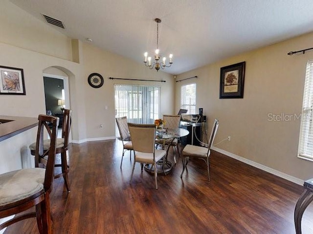 dining space featuring a notable chandelier, dark hardwood / wood-style floors, and vaulted ceiling