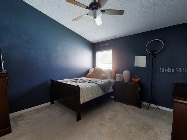 carpeted bedroom featuring a textured ceiling and ceiling fan