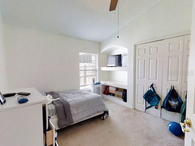 carpeted bedroom featuring ceiling fan, a closet, and a textured ceiling