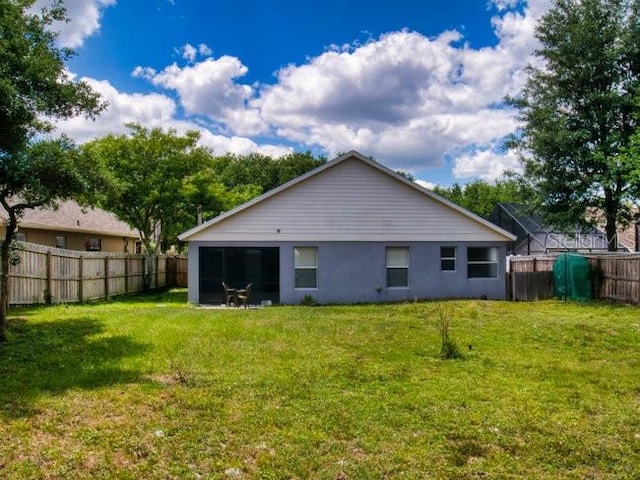 back of property with a lawn