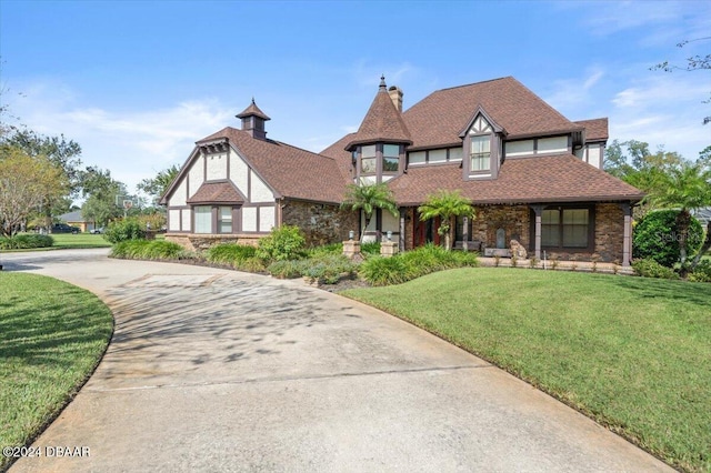 english style home featuring a front lawn