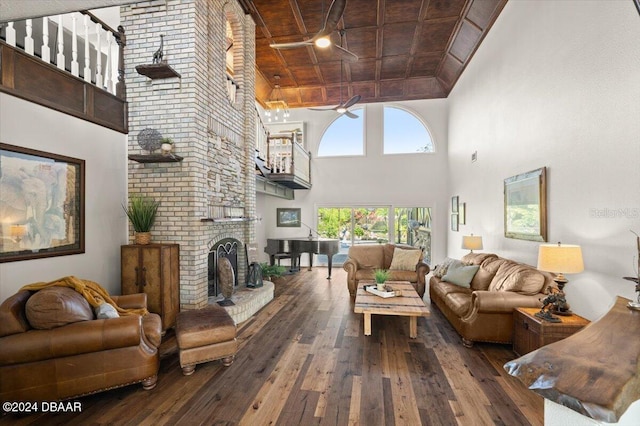 living room featuring wooden ceiling, dark wood-type flooring, coffered ceiling, ceiling fan, and a fireplace