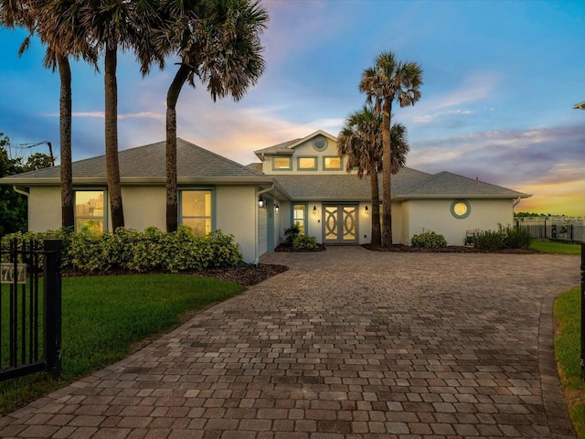 view of front of house featuring a lawn and french doors