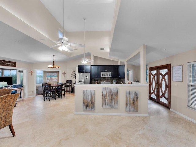 living room with ceiling fan with notable chandelier and vaulted ceiling