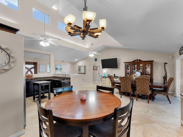 dining space with a towering ceiling and ceiling fan with notable chandelier