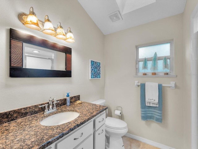 bathroom featuring tile patterned flooring, vanity, and toilet