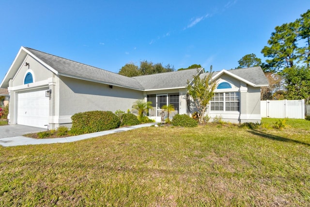 ranch-style home featuring a garage and a front lawn