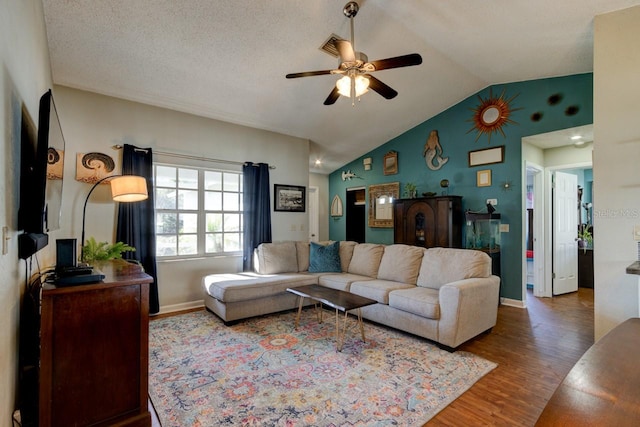 living room with a textured ceiling, ceiling fan, wood-type flooring, and lofted ceiling