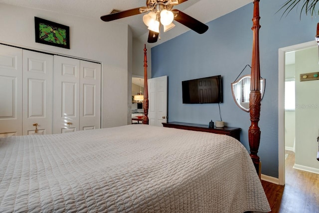 bedroom featuring lofted ceiling, ceiling fan, a closet, and dark hardwood / wood-style floors