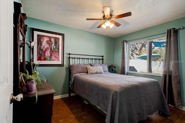 bedroom with ceiling fan, dark hardwood / wood-style floors, and a textured ceiling