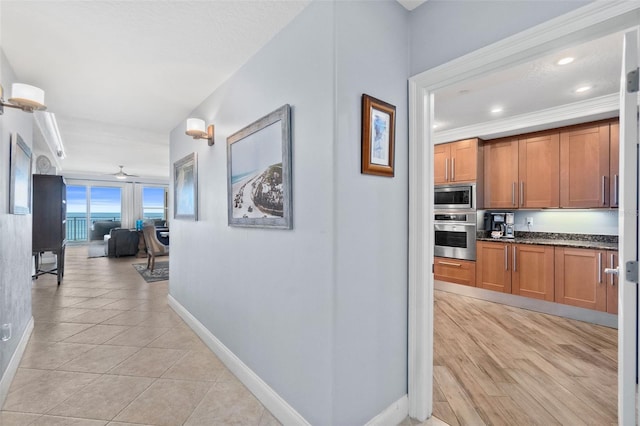 hall with crown molding and light tile patterned flooring