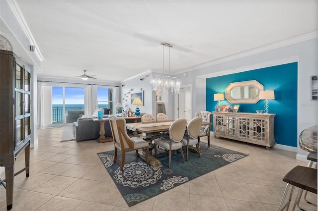 dining room featuring a water view, crown molding, light tile patterned floors, and ceiling fan with notable chandelier