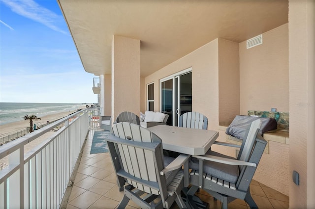 balcony featuring a water view and a beach view