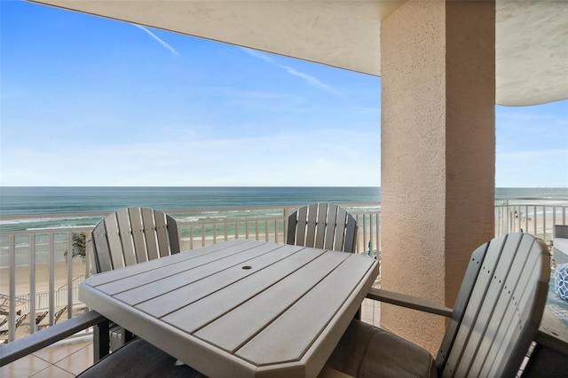 balcony with a water view and a view of the beach