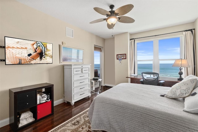 bedroom with ceiling fan, dark hardwood / wood-style flooring, and a water view