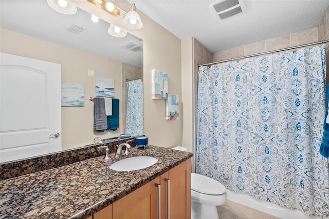 bathroom featuring vanity, toilet, and a textured ceiling