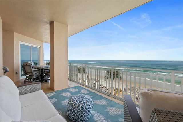 balcony featuring a water view and a beach view