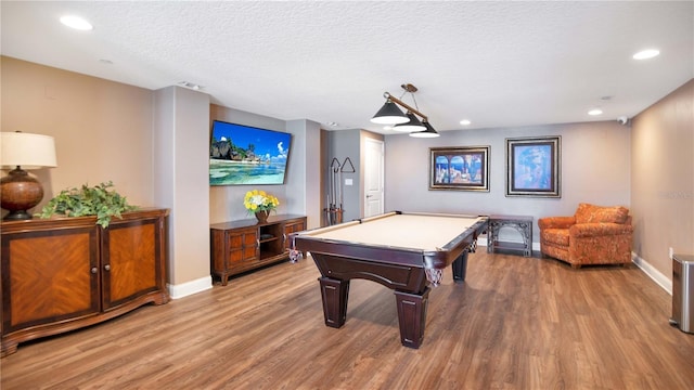 game room featuring light wood-type flooring, a textured ceiling, and pool table