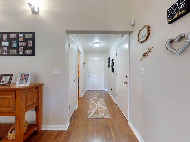 corridor with hardwood / wood-style floors