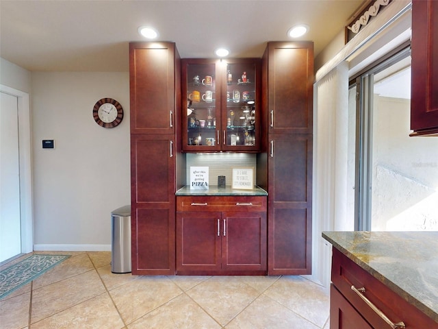 bar featuring light tile patterned floors, light stone countertops, and tasteful backsplash