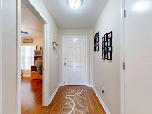 doorway to outside featuring wood-type flooring and a textured ceiling